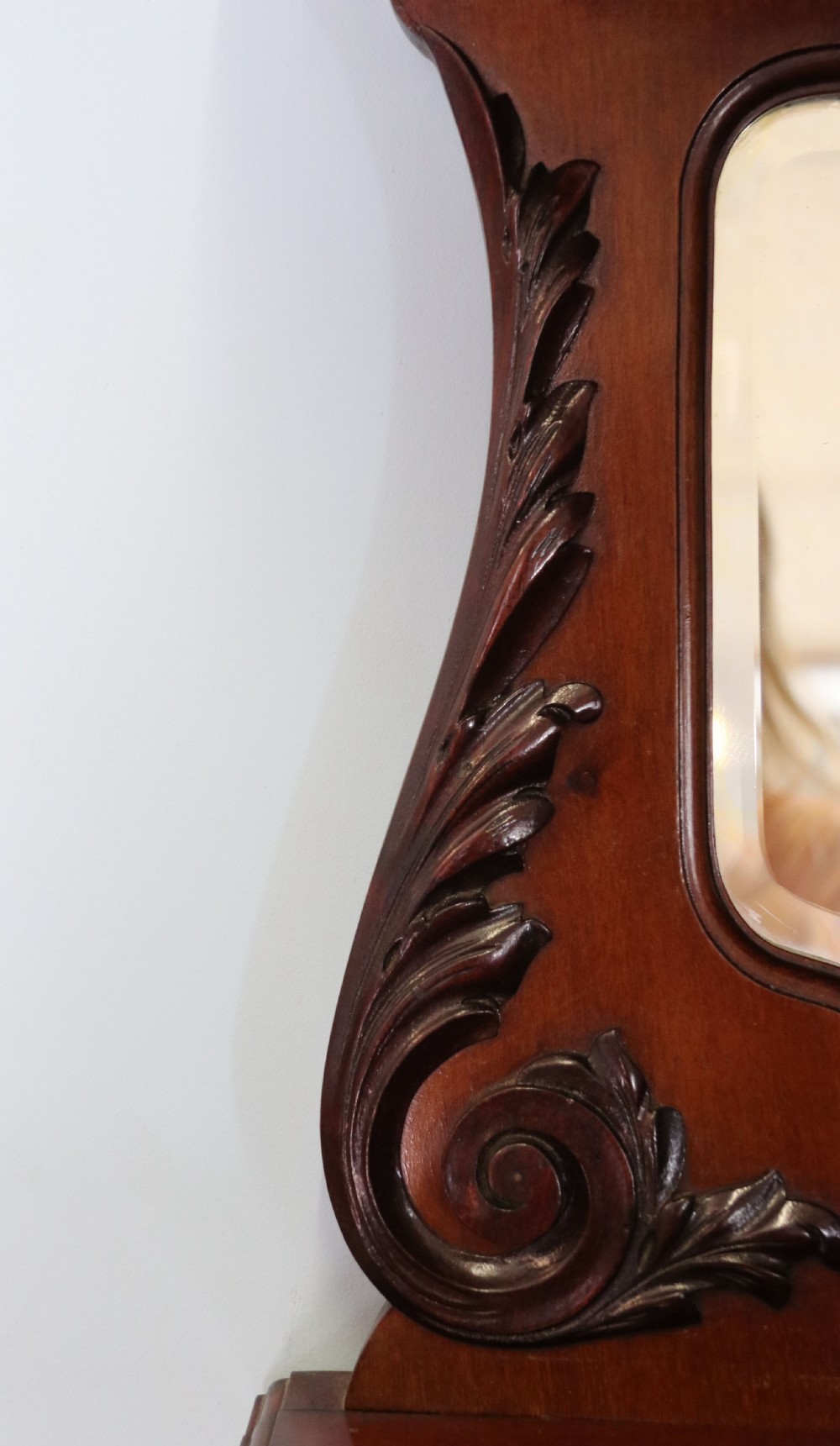 A late 19th-century mahogany display cabinet featuring a drop-centre mirror back, detailed floral marquetry inlays, glazed side doors, and a lower open shelf. View IX