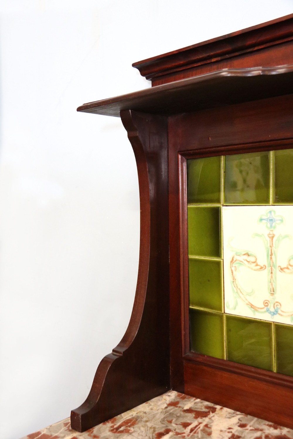 An Edwardian mahogany washstand featuring a red variegated marble top, a splashback set with green ceramic tiles, inlaid cupboard doors, and tapered legs. View XII