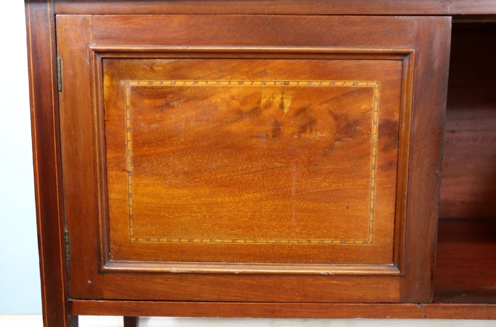 An Edwardian mahogany washstand featuring a red variegated marble top, a splashback set with green ceramic tiles, inlaid cupboard doors, and tapered legs. View XVII