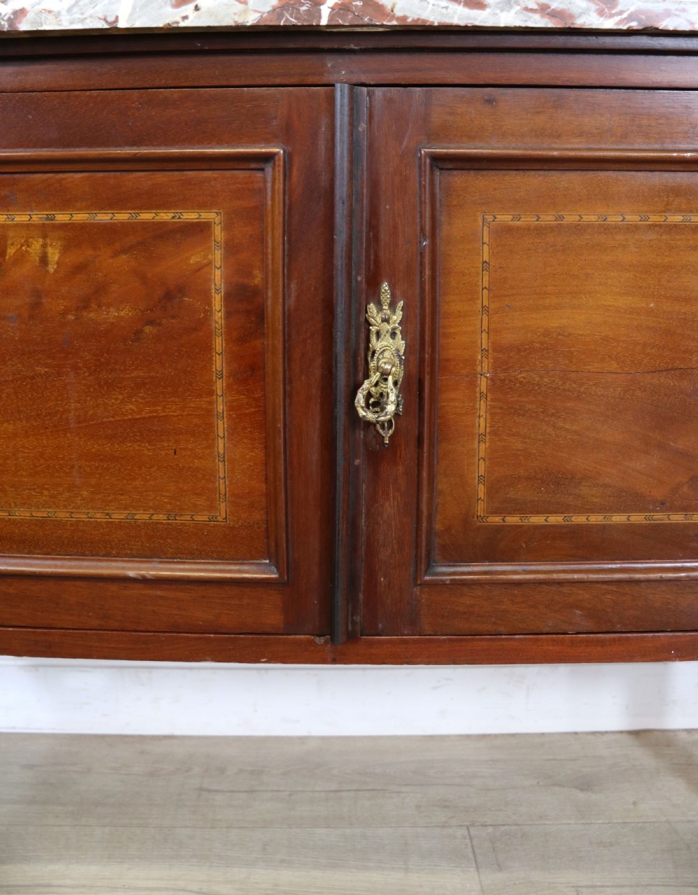 An Edwardian mahogany washstand featuring a red variegated marble top, a splashback set with green ceramic tiles, inlaid cupboard doors, and tapered legs. View XIX