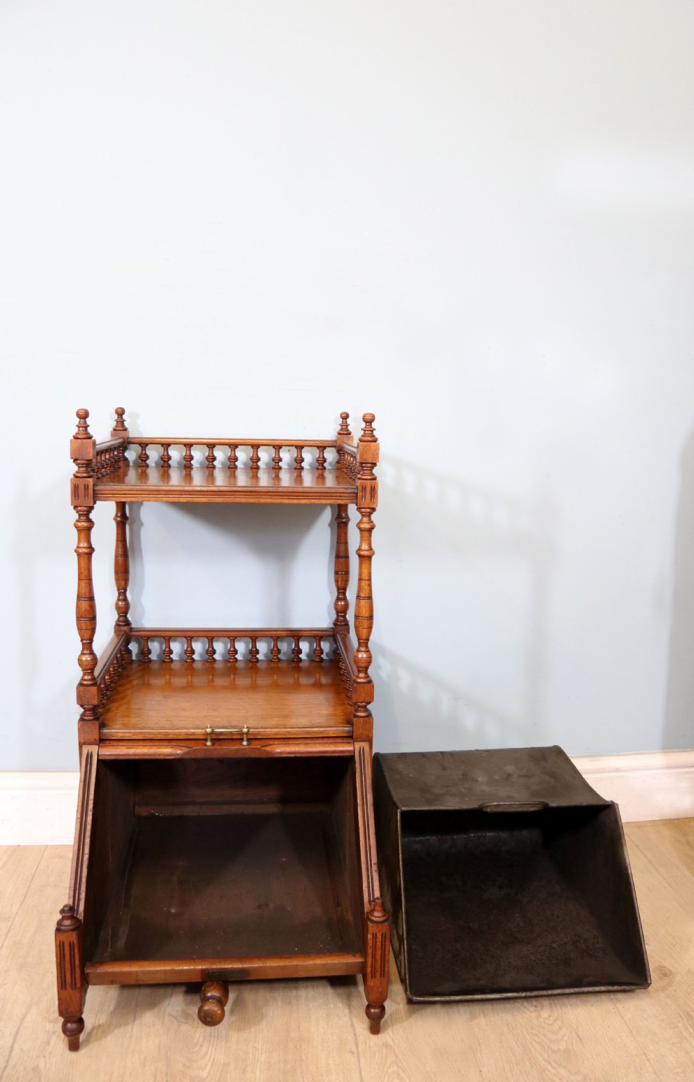A Victorian Gothic Revival solid walnut coal purdonium featuring a carved drop-front compartment, turned spindle galleries, and upper open shelves. View II