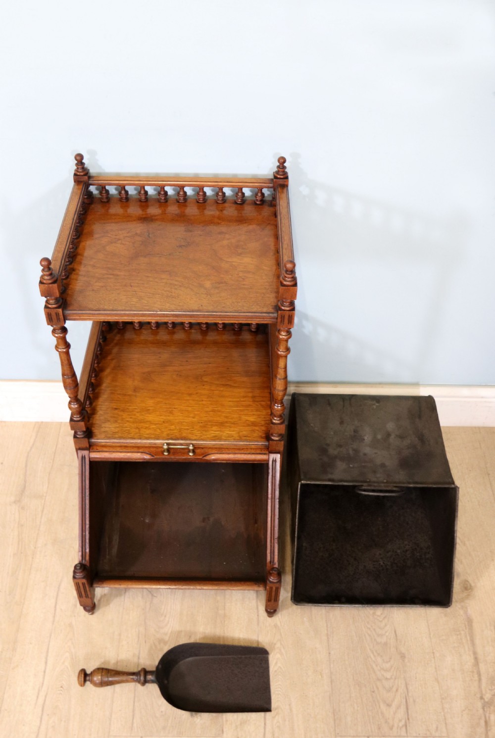 A Victorian Gothic Revival solid walnut coal purdonium featuring a carved drop-front compartment, turned spindle galleries, and upper open shelves. View VI