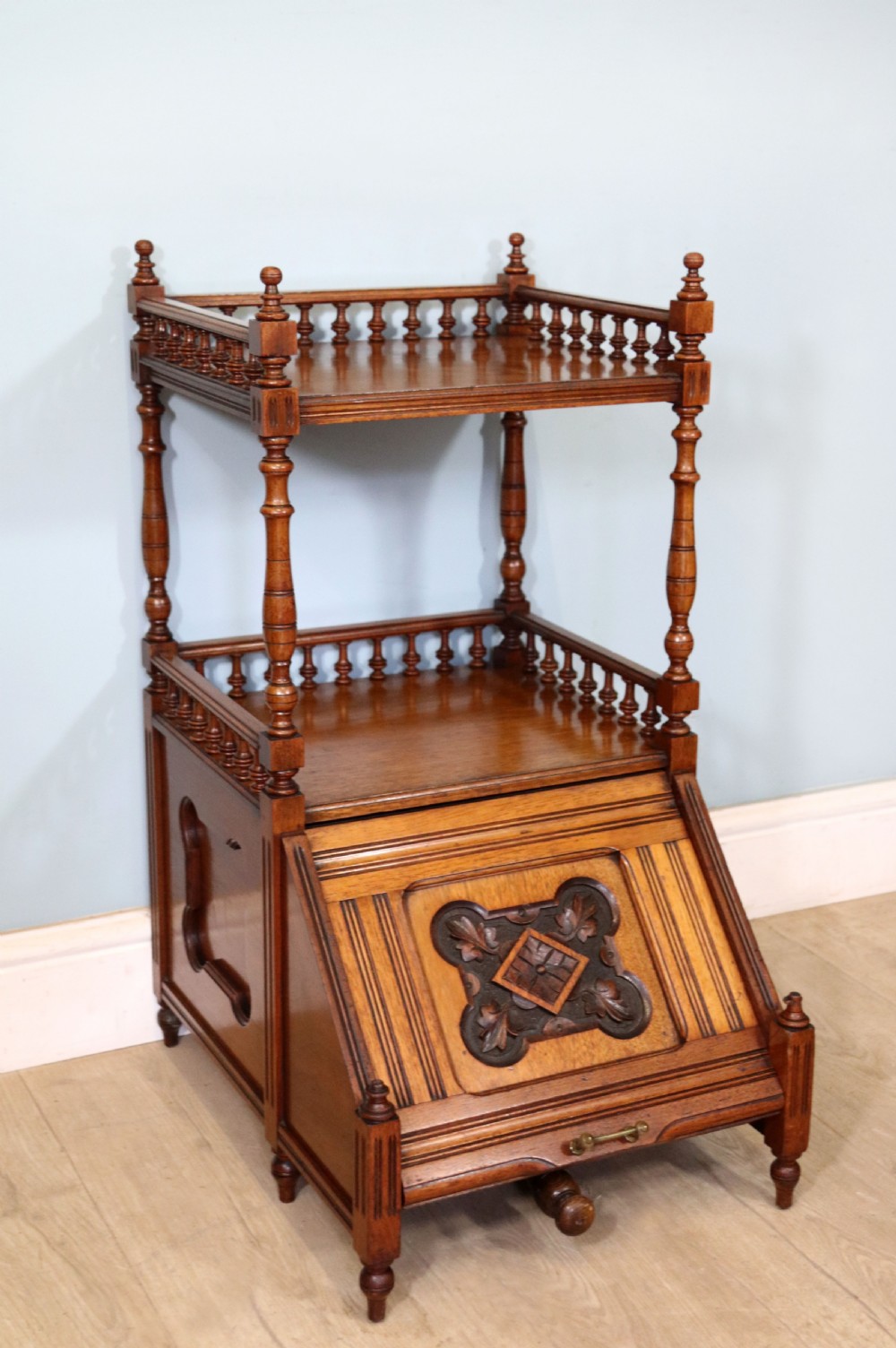 A Victorian Gothic Revival solid walnut coal purdonium featuring a carved drop-front compartment, turned spindle galleries, and upper open shelves. View VII