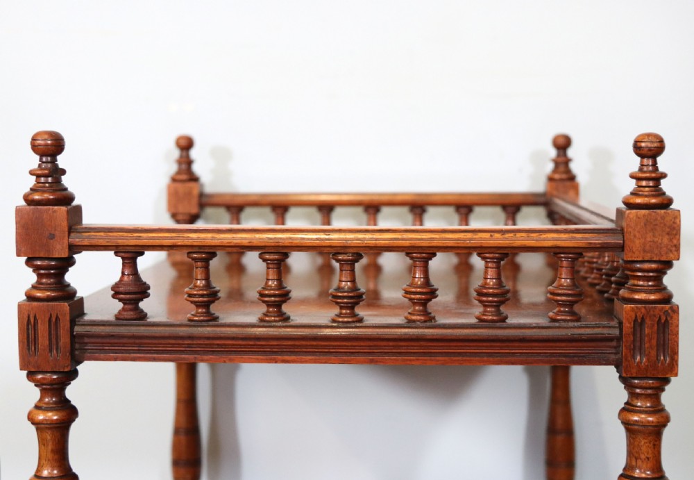 A Victorian Gothic Revival solid walnut coal purdonium featuring a carved drop-front compartment, turned spindle galleries, and upper open shelves. View X