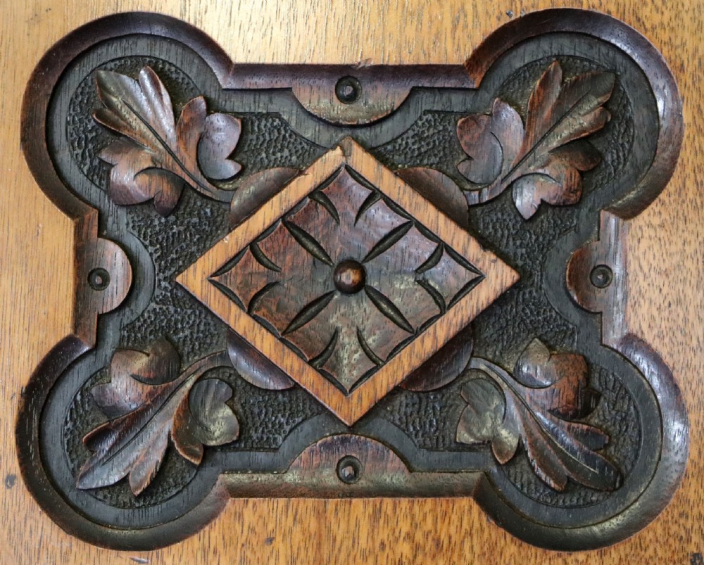 A Victorian Gothic Revival solid walnut coal purdonium featuring a carved drop-front compartment, turned spindle galleries, and upper open shelves. View XII