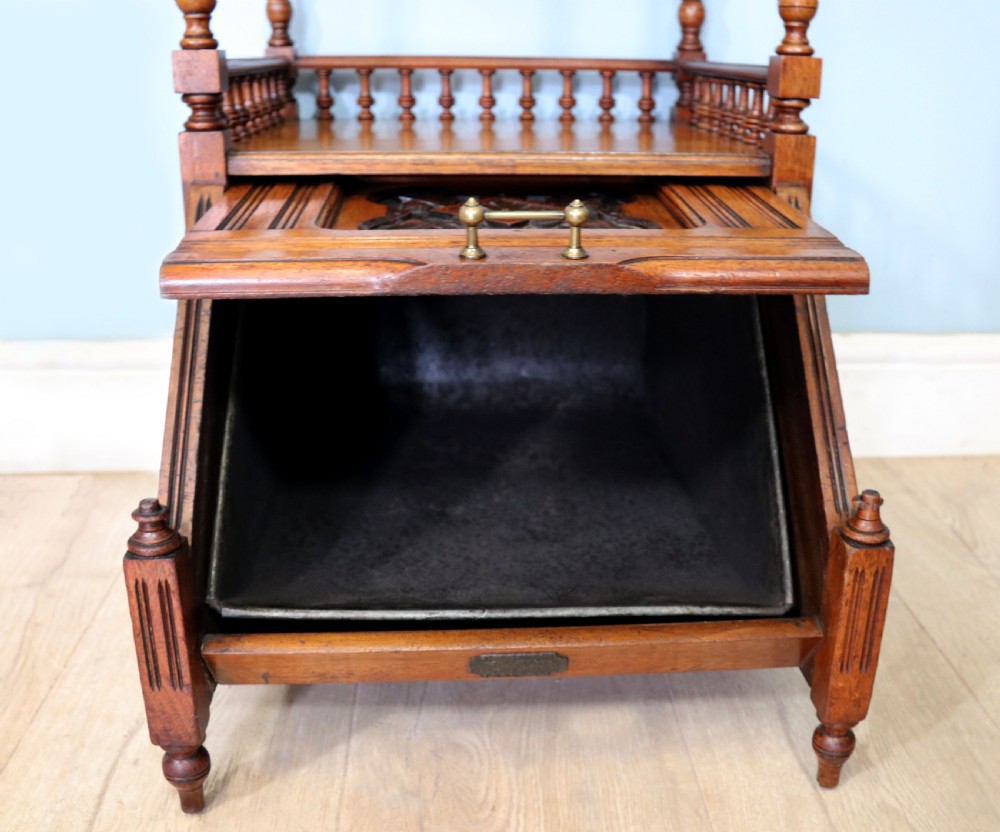 A Victorian Gothic Revival solid walnut coal purdonium featuring a carved drop-front compartment, turned spindle galleries, and upper open shelves. View XIII