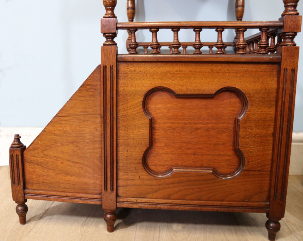 A Victorian Gothic Revival solid walnut coal purdonium featuring a carved drop-front compartment, turned spindle galleries, and upper open shelves. View XVI