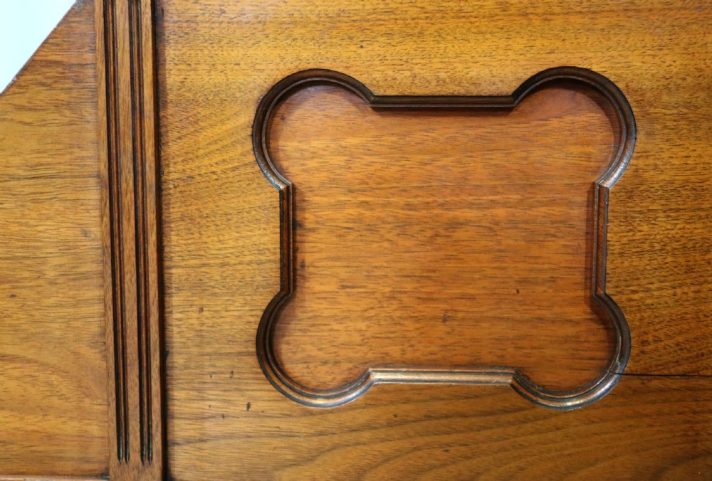 A Victorian Gothic Revival solid walnut coal purdonium featuring a carved drop-front compartment, turned spindle galleries, and upper open shelves. View XVII