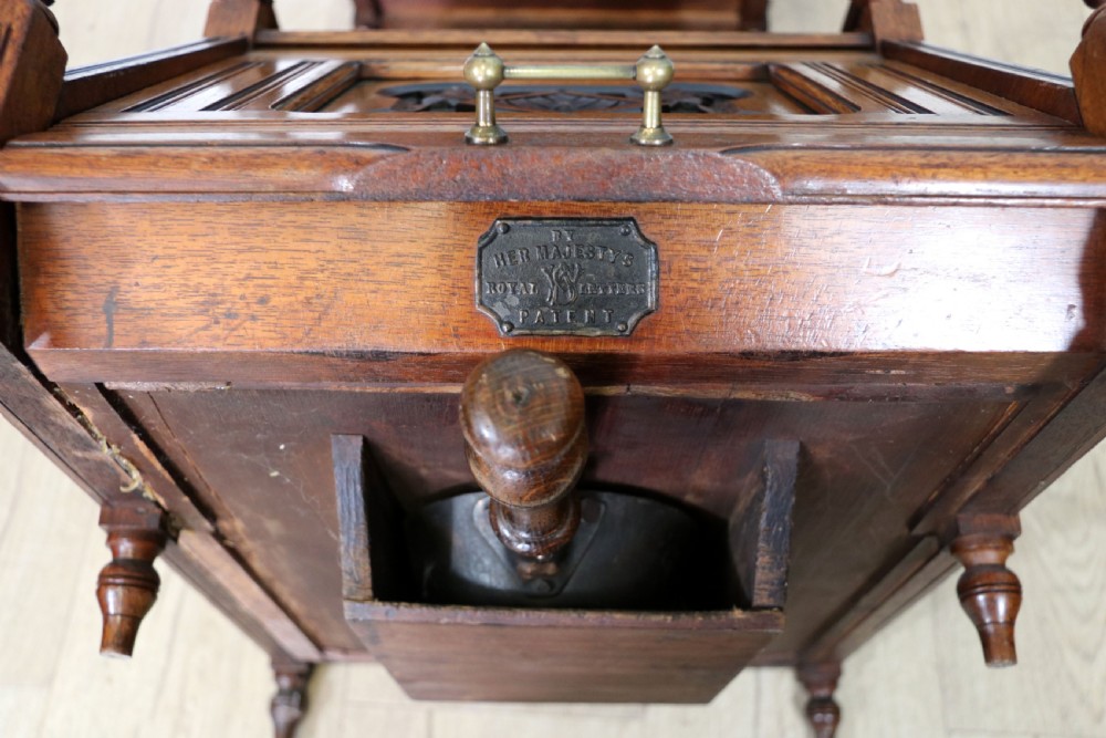 A Victorian Gothic Revival solid walnut coal purdonium featuring a carved drop-front compartment, turned spindle galleries, and upper open shelves. View XVIII