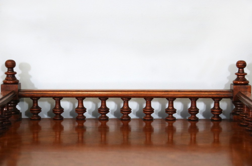 A Victorian Gothic Revival solid walnut coal purdonium featuring a carved drop-front compartment, turned spindle galleries, and upper open shelves. View XXIV