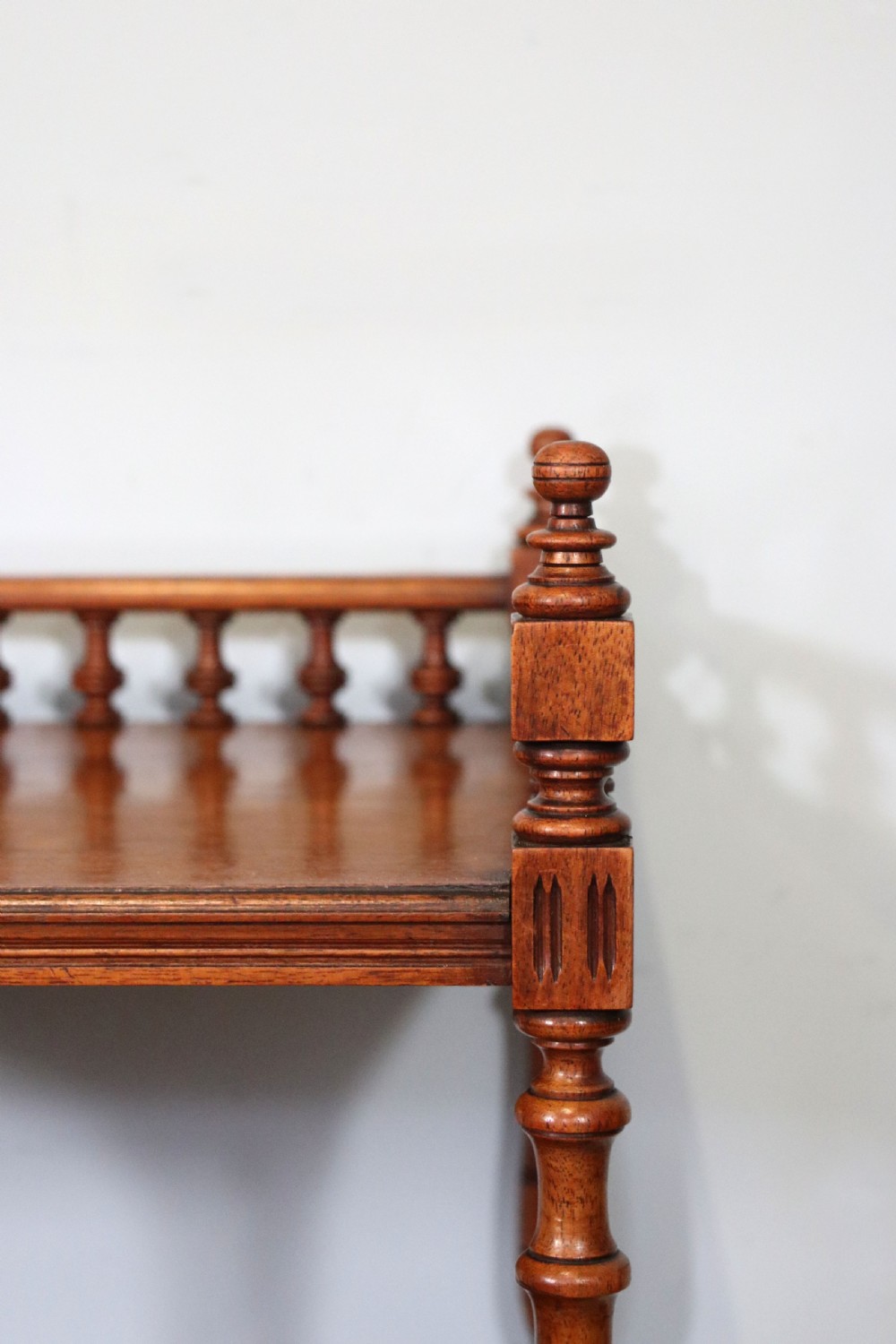 A Victorian Gothic Revival solid walnut coal purdonium featuring a carved drop-front compartment, turned spindle galleries, and upper open shelves. View XXV