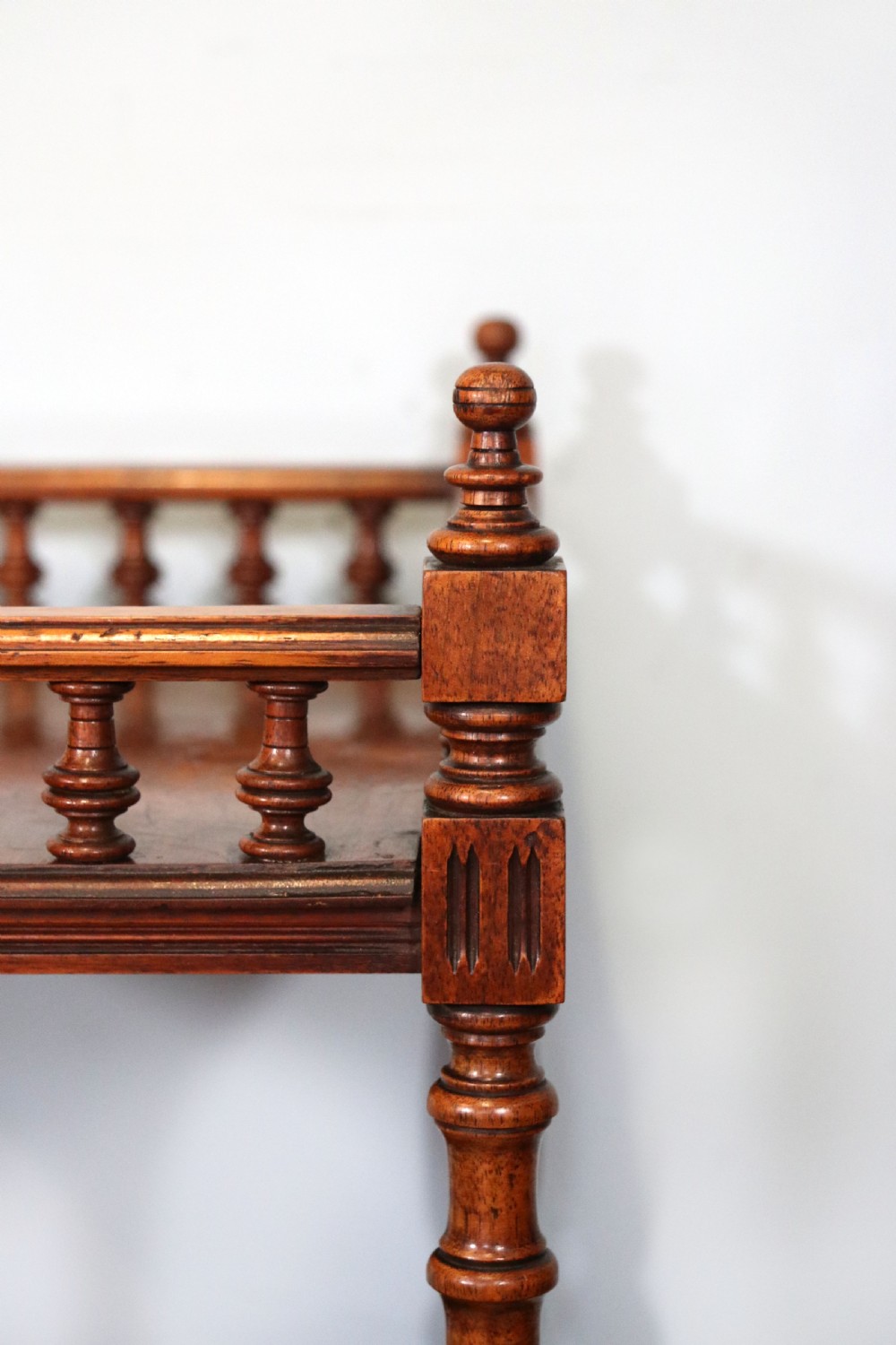 A Victorian Gothic Revival solid walnut coal purdonium featuring a carved drop-front compartment, turned spindle galleries, and upper open shelves. View XXVI