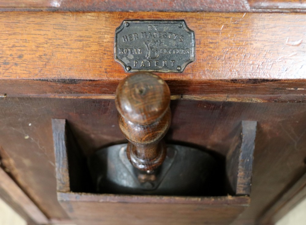 A Victorian Gothic Revival solid walnut coal purdonium featuring a carved drop-front compartment, turned spindle galleries, and upper open shelves. View XXVII