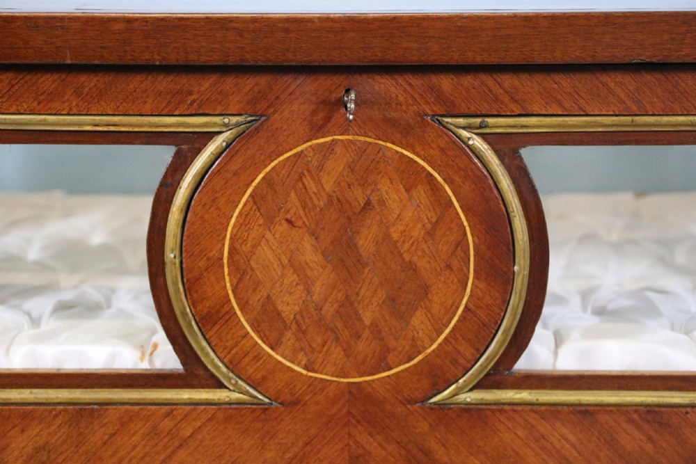 A mahogany and kingwood veneered bijouterie display table featuring glazed panels, cabriole legs with brass mounts, and a buttoned cream interior. View XVI