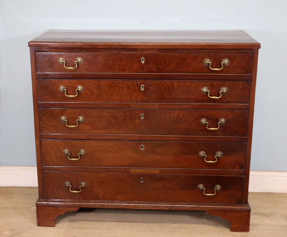 A 19th-century mahogany chest of drawers featuring five graduated drawers with brass swan-neck handles and bracket feet.