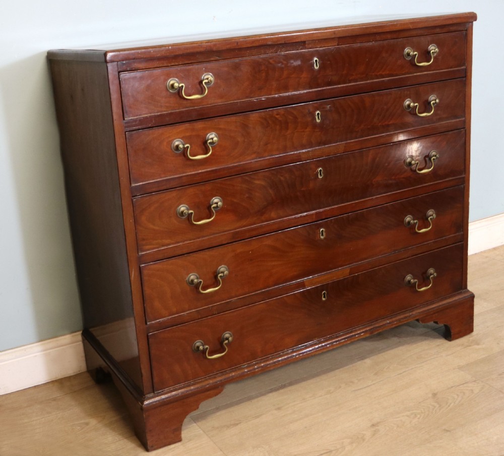 A 19th-century mahogany chest of drawers featuring five graduated drawers with brass swan-neck handles and bracket feet. View IV