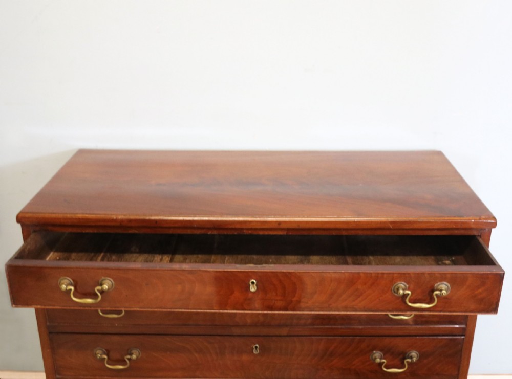 A 19th-century mahogany chest of drawers featuring five graduated drawers with brass swan-neck handles and bracket feet. View VI