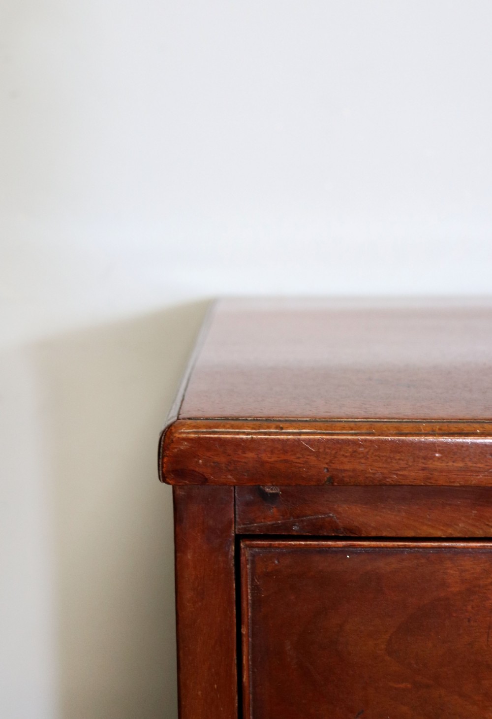 A 19th-century mahogany chest of drawers featuring five graduated drawers with brass swan-neck handles and bracket feet. View VII