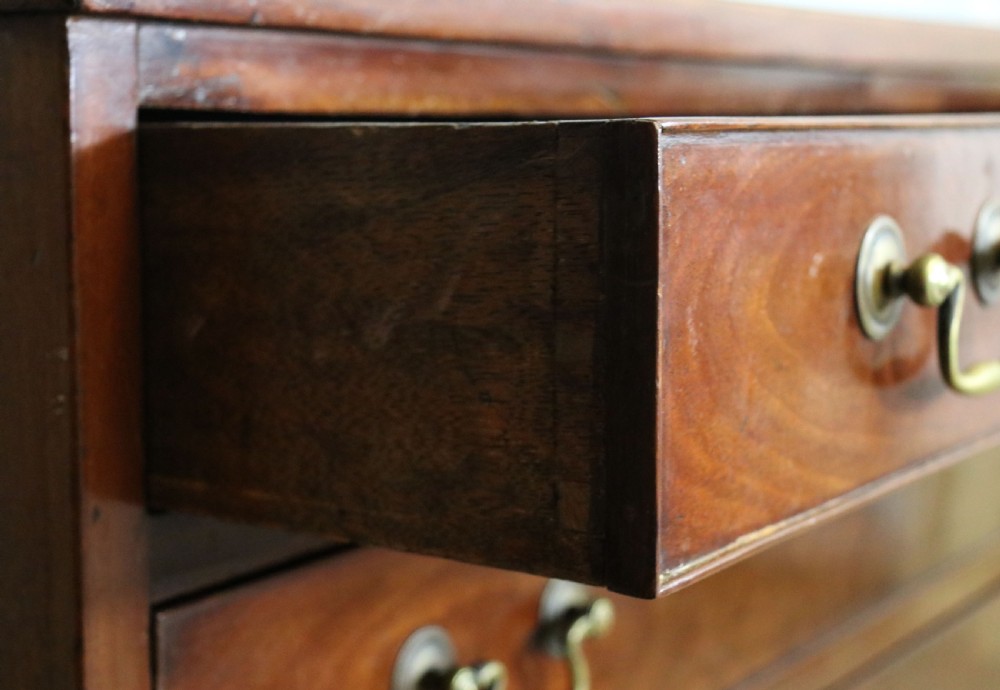A 19th-century mahogany chest of drawers featuring five graduated drawers with brass swan-neck handles and bracket feet. View XI