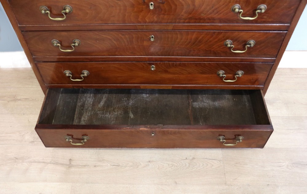 A 19th-century mahogany chest of drawers featuring five graduated drawers with brass swan-neck handles and bracket feet. View XII