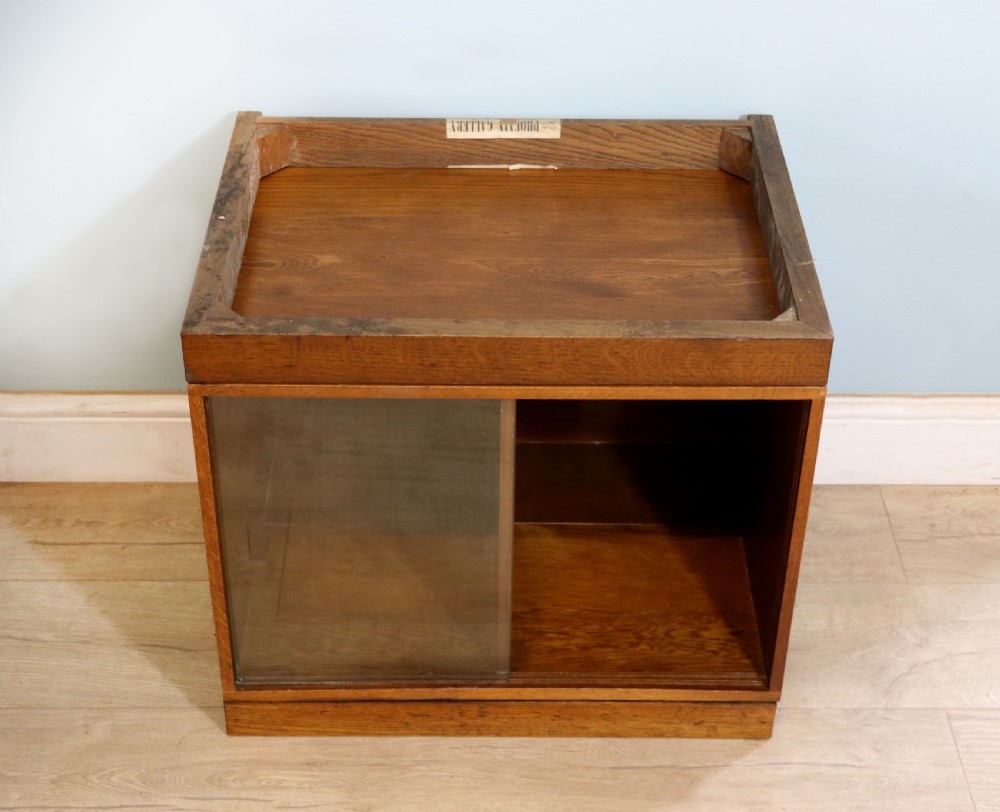A three-tier mid-century oak sectional bookcase featuring sliding glass doors and a central section with a solid wood panel. View XIII
