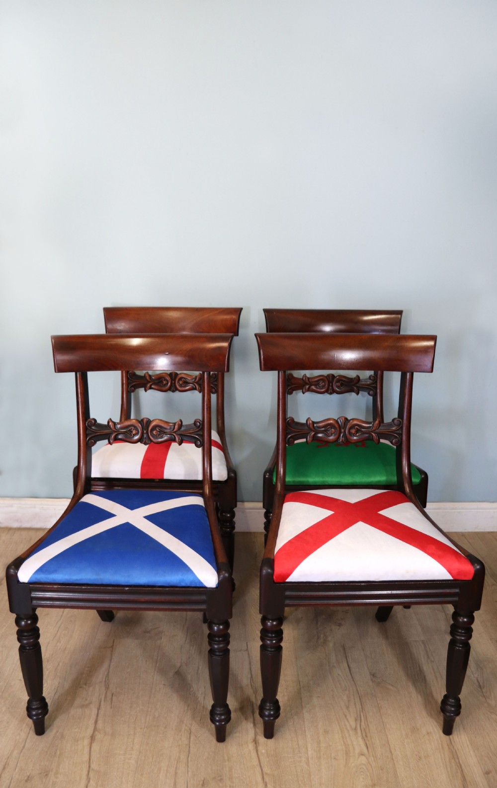 A set of four Victorian mahogany bar-back dining chairs with carved mid-rails, turned front legs, and flag-patterned upholstered seats.