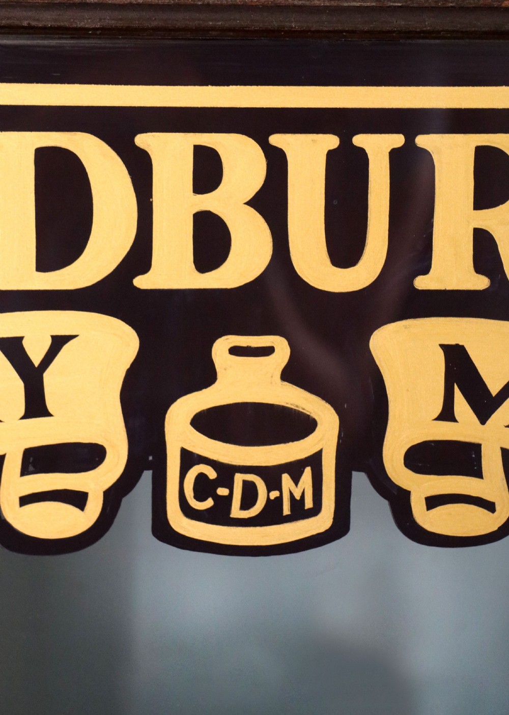 A dark hardwood rectangular shop display cabinet featuring gold lettering on the front glass pane reading Cadburys Dairy Milk Chocolate. View VIII