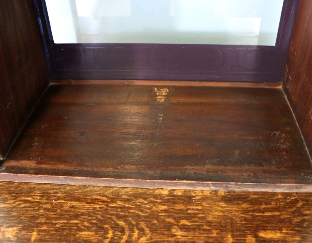 A dark hardwood rectangular shop display cabinet featuring gold lettering on the front glass pane reading Cadburys Dairy Milk Chocolate. View XV