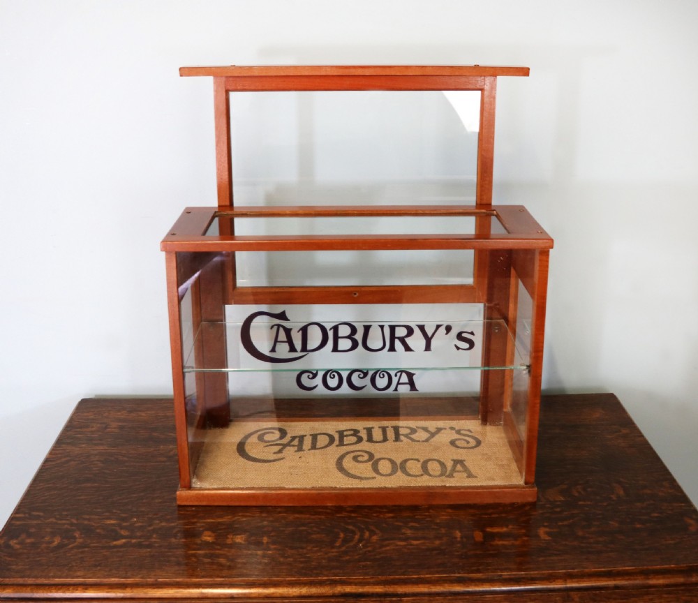 A glazed hardwood countertop display cabinet featuring Cadburys Cocoa typography printed on the front glass pane and inner base. View III