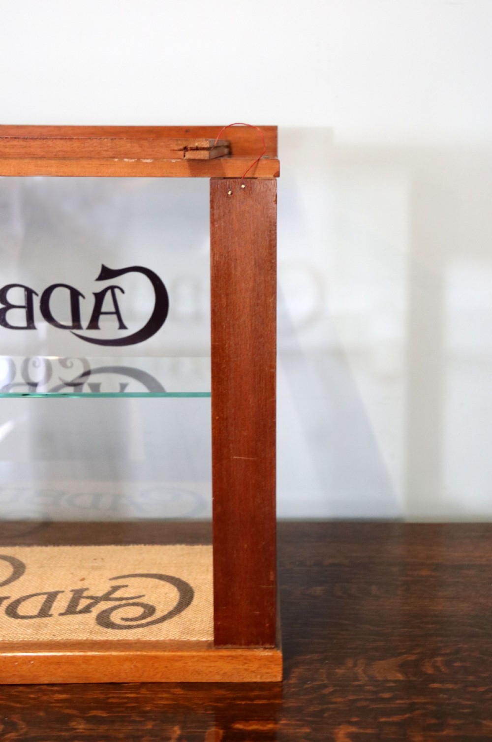 A glazed hardwood countertop display cabinet featuring Cadburys Cocoa typography printed on the front glass pane and inner base. View XII