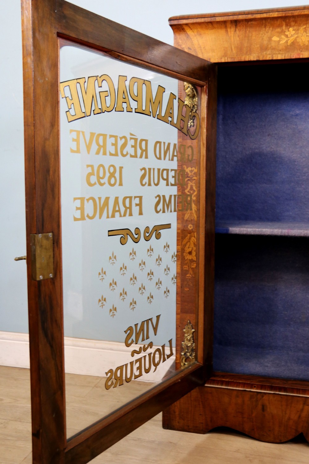 A lovely Victorian walnut and floral inlaid pier cabinet, later sign written in French with Champagne advertising. View XXIV