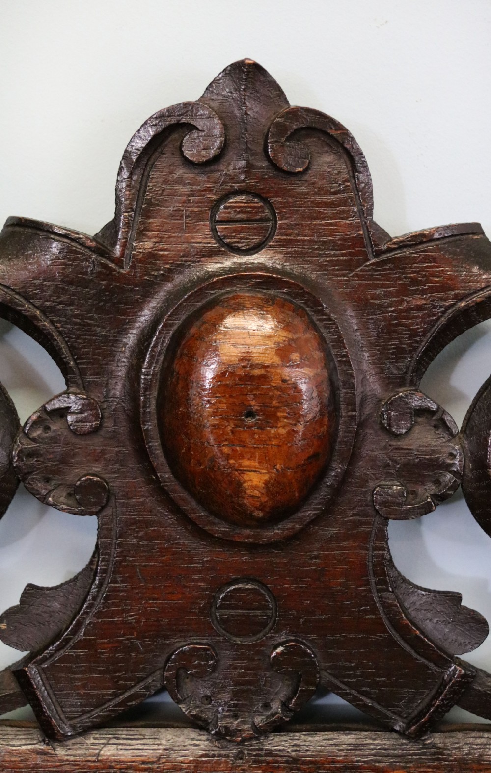 A dark carved oak side cabinet with a single glazed door displaying painted brewery signwriting and an ornate carved gallery back. View VIII