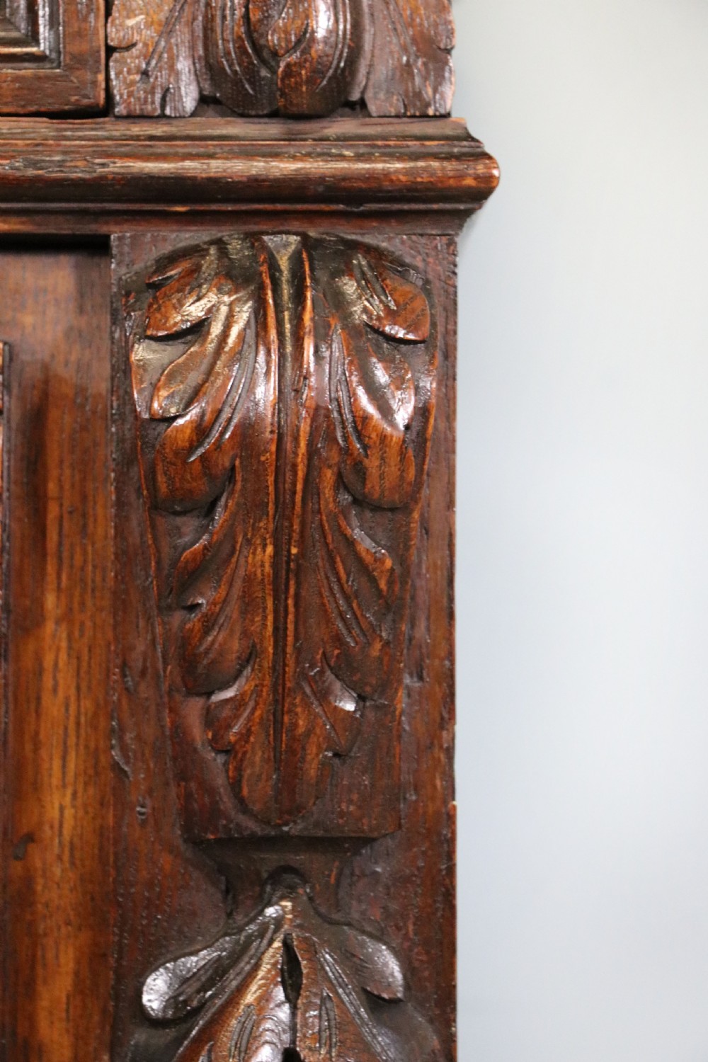 A dark carved oak side cabinet with a single glazed door displaying painted brewery signwriting and an ornate carved gallery back. View XVIII