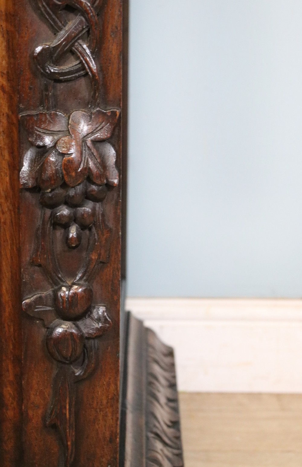 A dark carved oak side cabinet with a single glazed door displaying painted brewery signwriting and an ornate carved gallery back. View XX