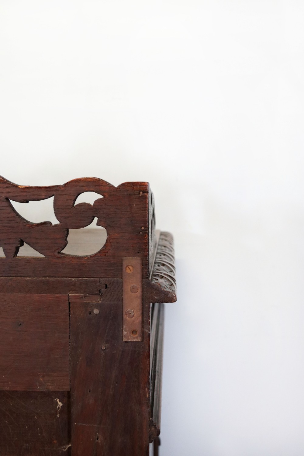 A dark carved oak side cabinet with a single glazed door displaying painted brewery signwriting and an ornate carved gallery back. View XXIV