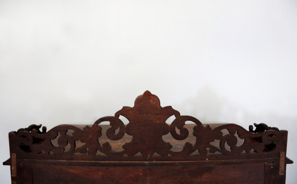 A dark carved oak side cabinet with a single glazed door displaying painted brewery signwriting and an ornate carved gallery back. View XXV