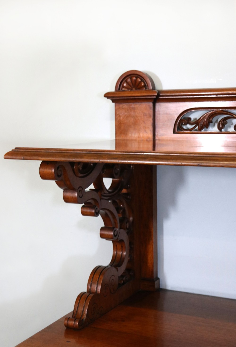 A Victorian pollard oak sideboard featuring a carved upper display shelf, fretwork cresting, and two fielded panel doors with decorative wood grain. View VIII