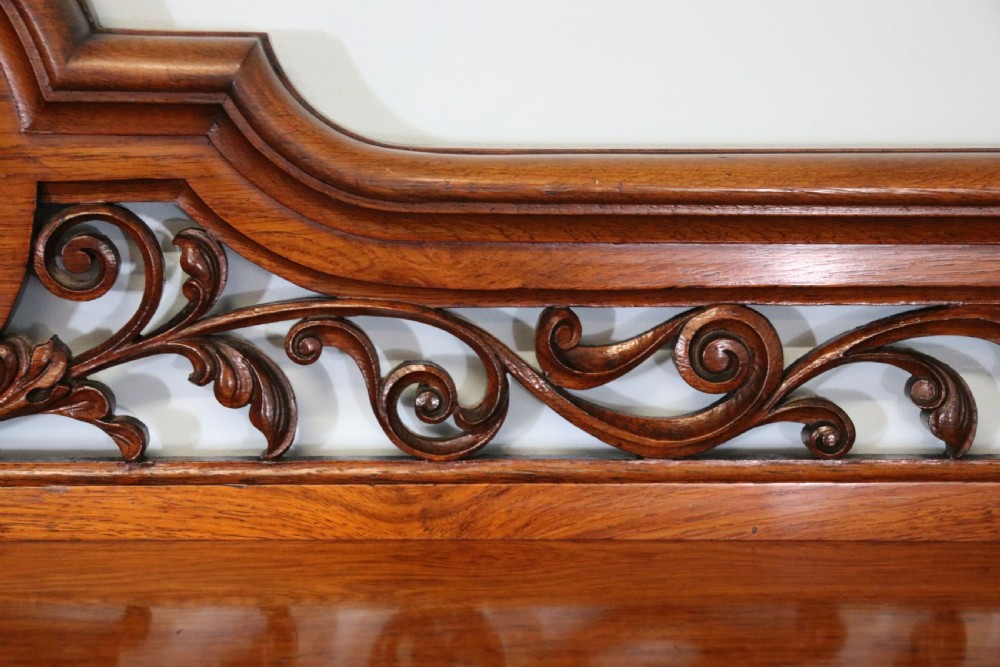 A Victorian pollard oak sideboard featuring a carved upper display shelf, fretwork cresting, and two fielded panel doors with decorative wood grain. View XIII