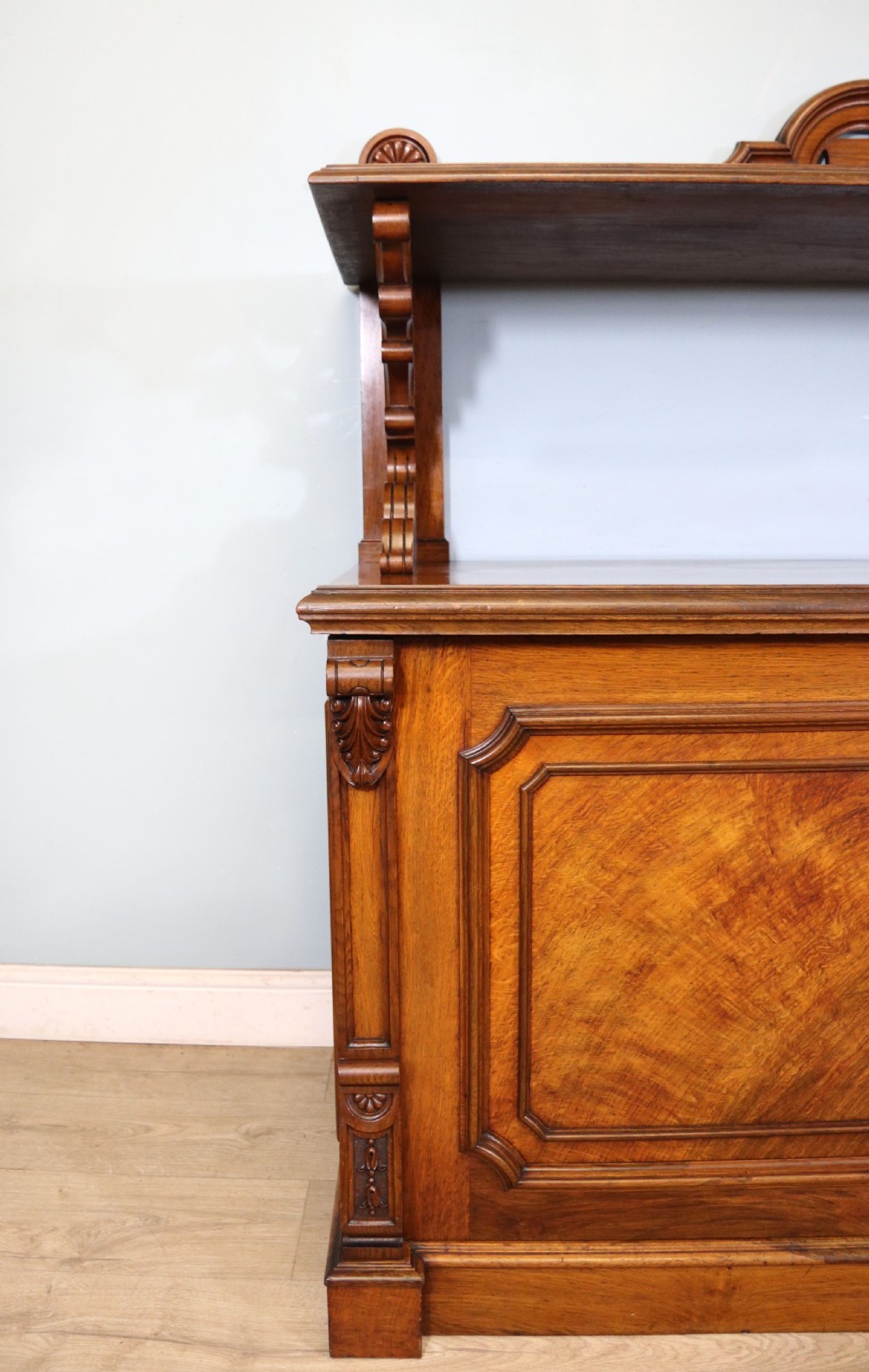 A Victorian pollard oak sideboard featuring a carved upper display shelf, fretwork cresting, and two fielded panel doors with decorative wood grain. View XX