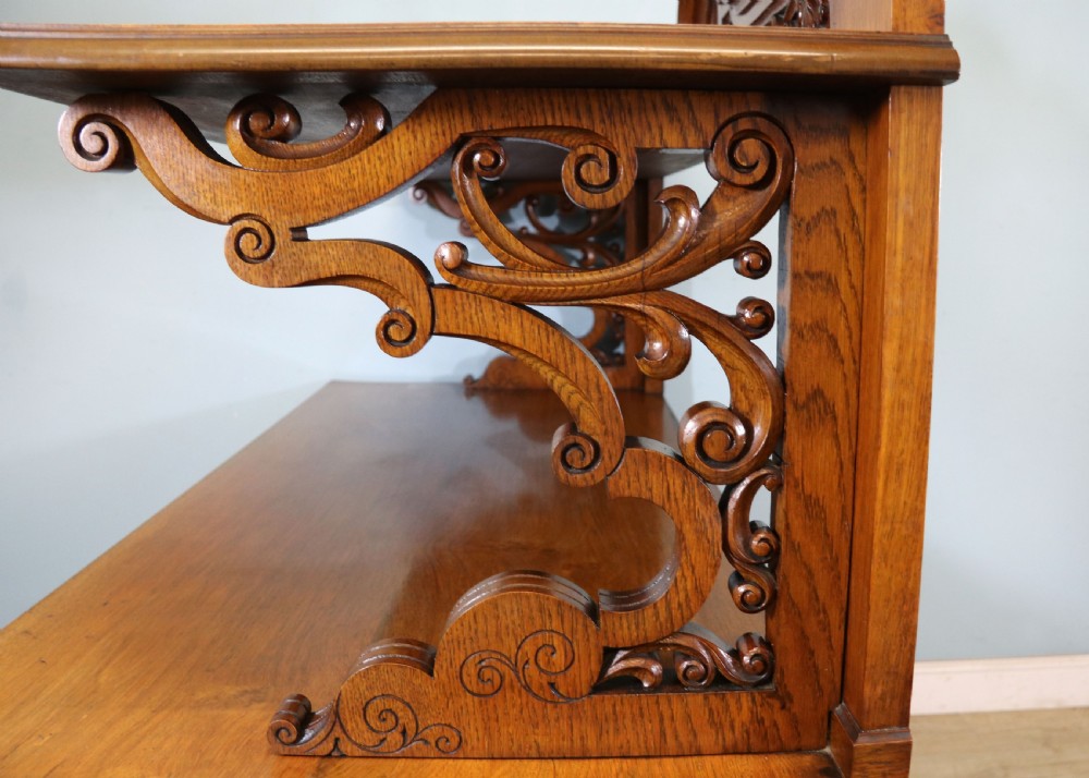 A Victorian pollard oak sideboard featuring a carved upper display shelf, fretwork cresting, and two fielded panel doors with decorative wood grain. View XXII