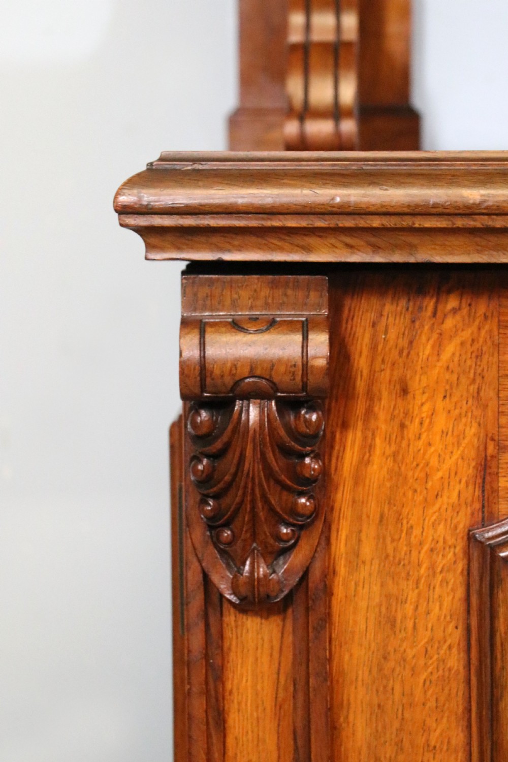 A Victorian pollard oak sideboard featuring a carved upper display shelf, fretwork cresting, and two fielded panel doors with decorative wood grain. View XXIV
