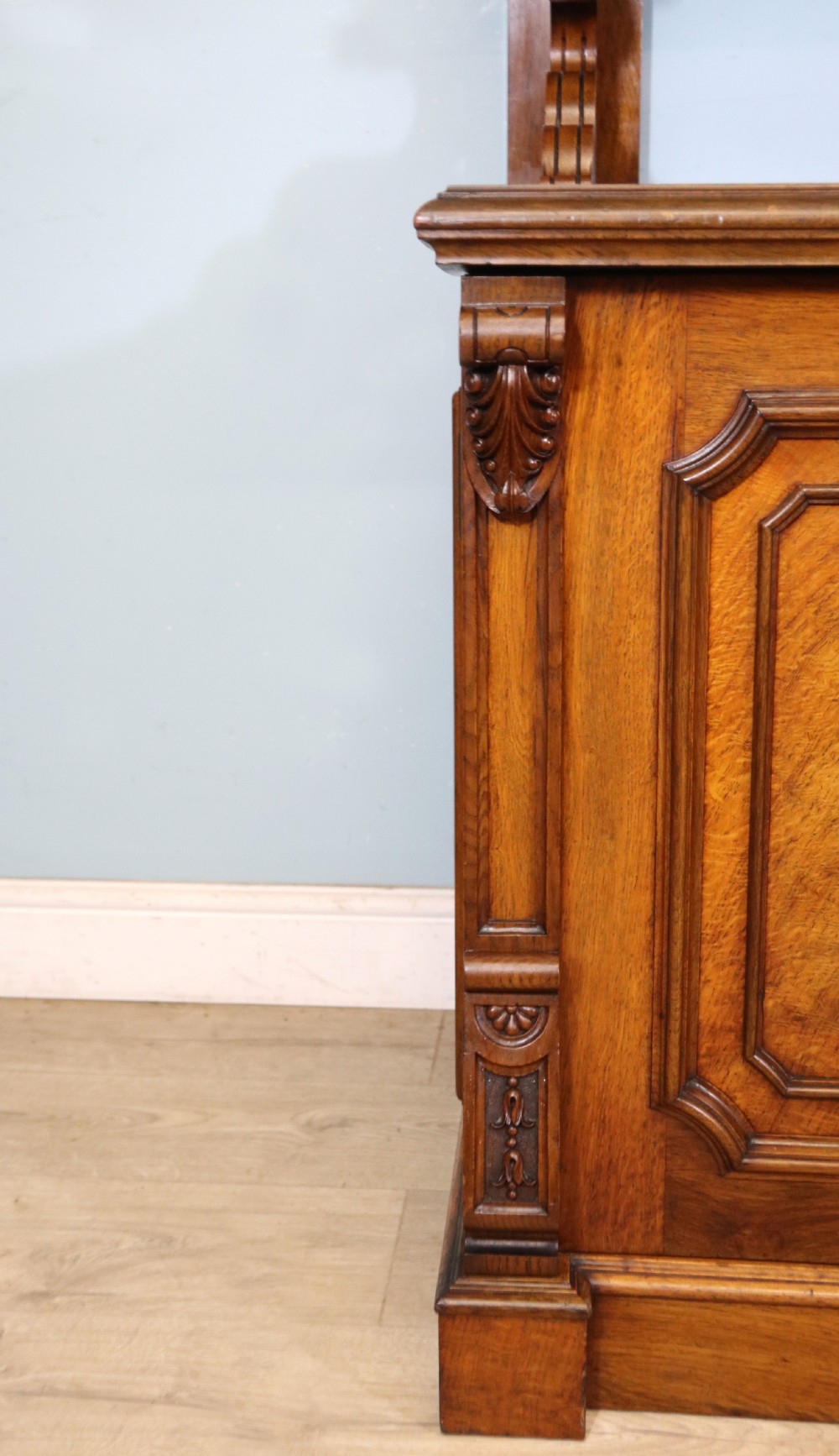 A Victorian pollard oak sideboard featuring a carved upper display shelf, fretwork cresting, and two fielded panel doors with decorative wood grain. View XXV