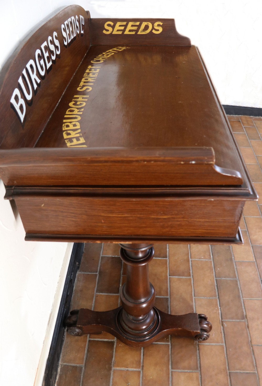 A late Victorian mahogany galleried side table featuring two drawers, turned legs on a trestle base, and painted commercial lettering. View VI
