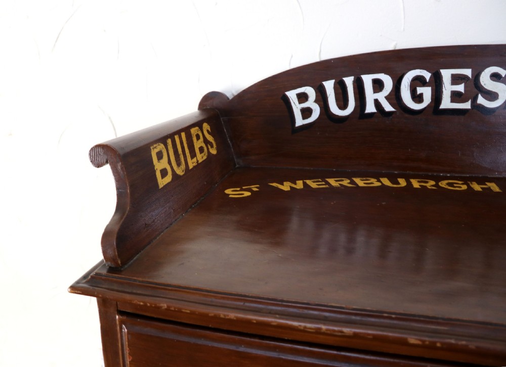 A late Victorian mahogany galleried side table featuring two drawers, turned legs on a trestle base, and painted commercial lettering. View IX