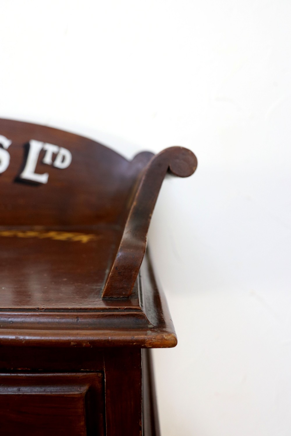 A late Victorian mahogany galleried side table featuring two drawers, turned legs on a trestle base, and painted commercial lettering. View XIV