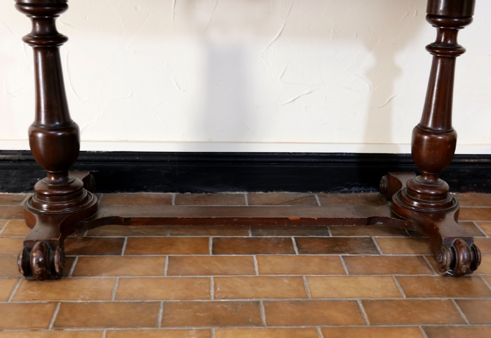 A late Victorian mahogany galleried side table featuring two drawers, turned legs on a trestle base, and painted commercial lettering. View XVIII