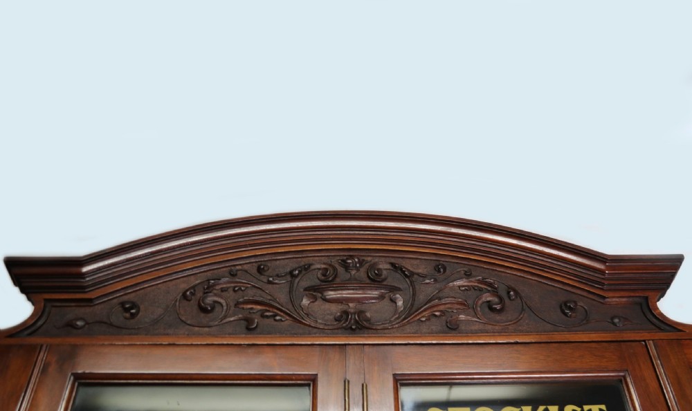 A tall Victorian solid walnut shop cabinet with glazed upper doors featuring sign-written fishing typography, multiple small drawers in the midsection, and panelled cupboard doors below. View VIII