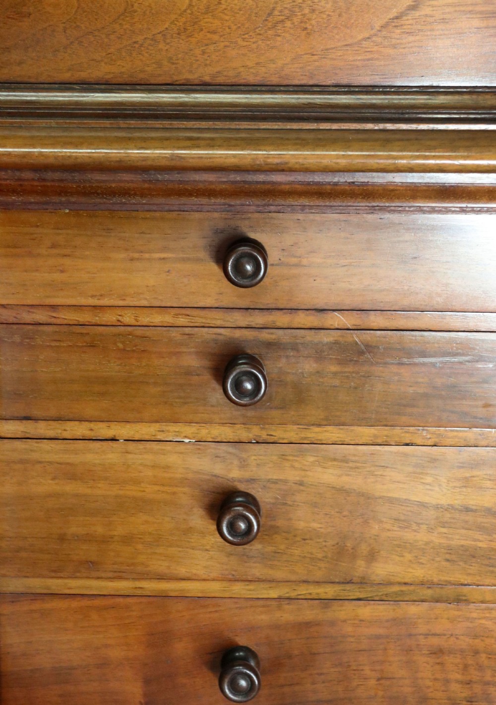 A tall Victorian solid walnut shop cabinet with glazed upper doors featuring sign-written fishing typography, multiple small drawers in the midsection, and panelled cupboard doors below. View XXVI