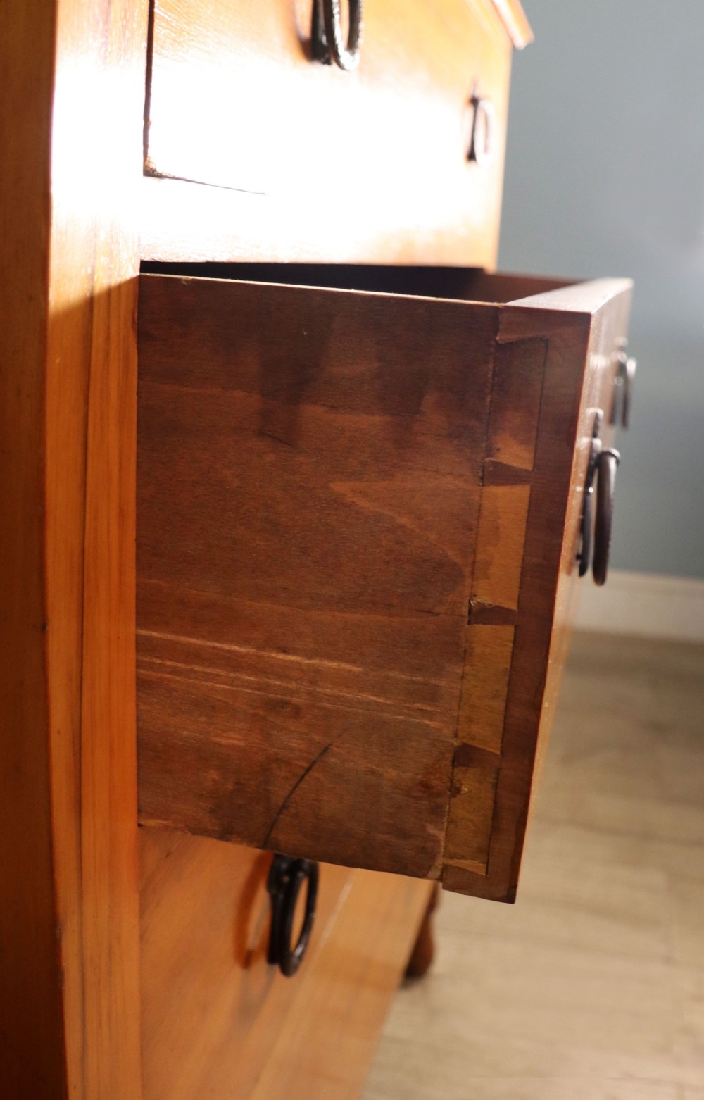 A late Victorian American walnut chest of drawers featuring four full-width drawers with metal drop-ring handles, a low shaped gallery upstand, and turned feet. View VIII