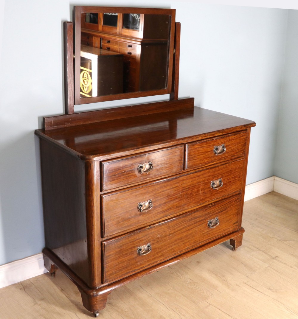 A dark mahogany Victorian dressing chest featuring a rectangular pivoting top mirror and four drawers with metal drop handles. View III